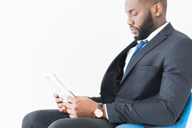 black businessman in suit with newspaper 