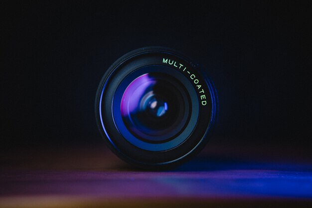 Black camera lens on blue surface