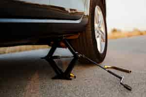 Free photo black car lifted up by a jack-screw