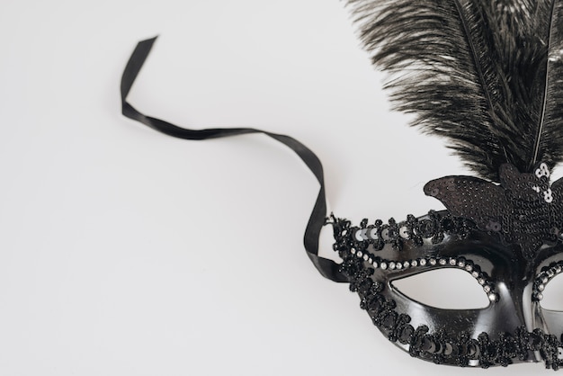 Foto gratuita maschera di carnevale nero con piuma sul tavolo