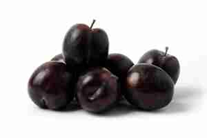 Free photo black cherry plums on the white table