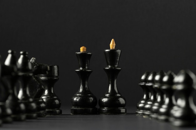 Черные шахматные фигуры на черном фоне