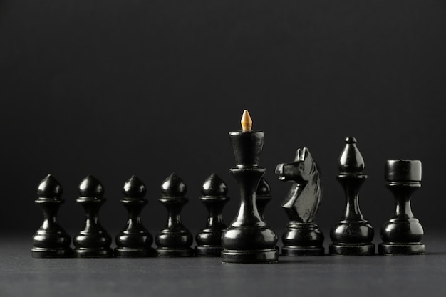 Black chess pieces on black background