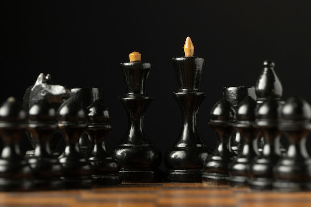 Black chess pieces on chess board. king and queen pieces.