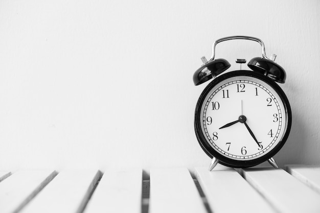 Black clock on table with copy space