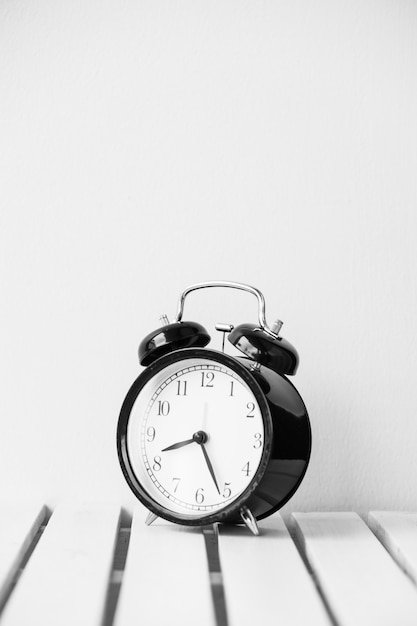 Black clock on table with copy space