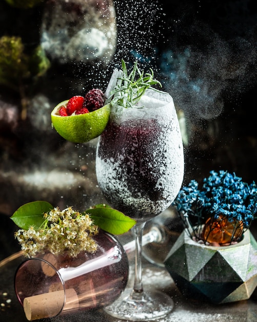 Free photo black cocktail with vanilla powder and berries.