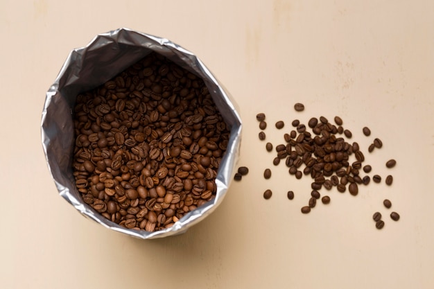 ベージュ色の背景にブラックコーヒー豆の配置