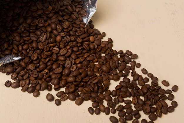 Черный кофе в зернах на бежевом фоне