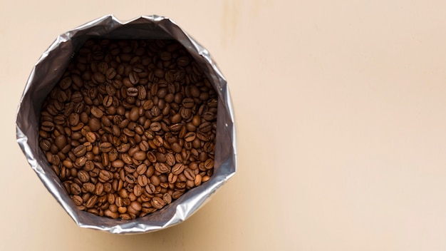 Black coffee beans on beige background with copy space