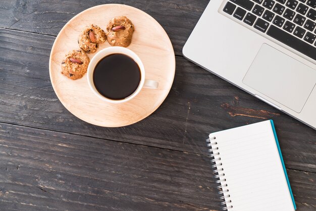 black coffee and cookies with laptop and note book