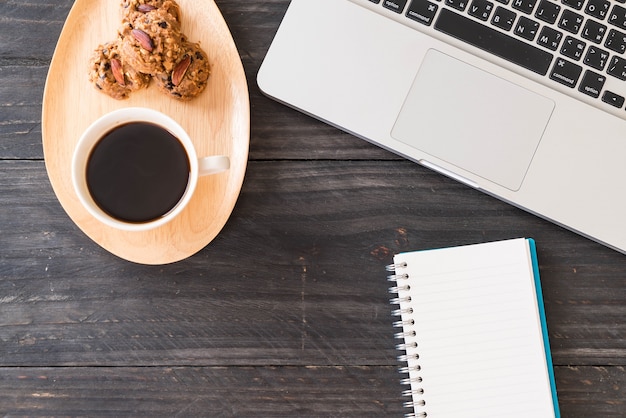 black coffee and cookies with laptop and note book