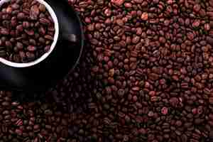 Free photo black coffee cup with roasted beans background