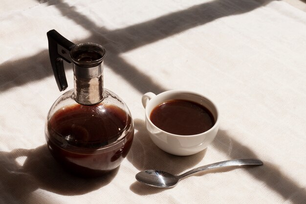 Foto gratuita caffè nero in tazza con cucchiaino