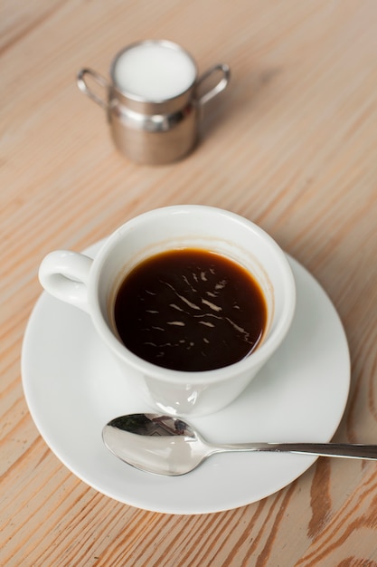 Caffè nero con latte sulla scrivania al negozio di caffè