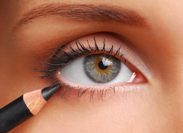 Black cosmetic pencil. Beautiful  women eye close-up.