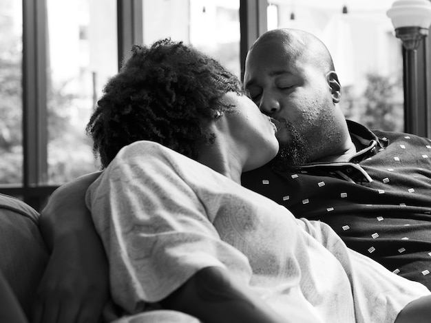 Free photo black couple kissing on the couch