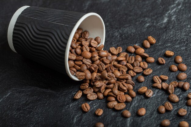 나무 보드에 커피 콩의 전체 검은 컵.