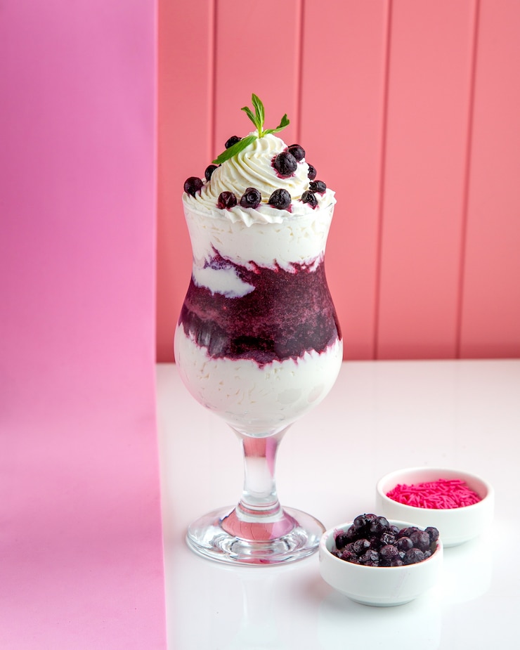 Free Photo black currant dessert with whipped cream and black currant jam and berries on table