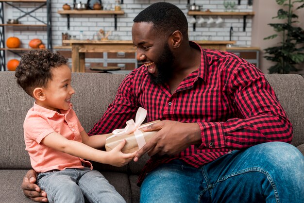 black cute son giving gift to father
