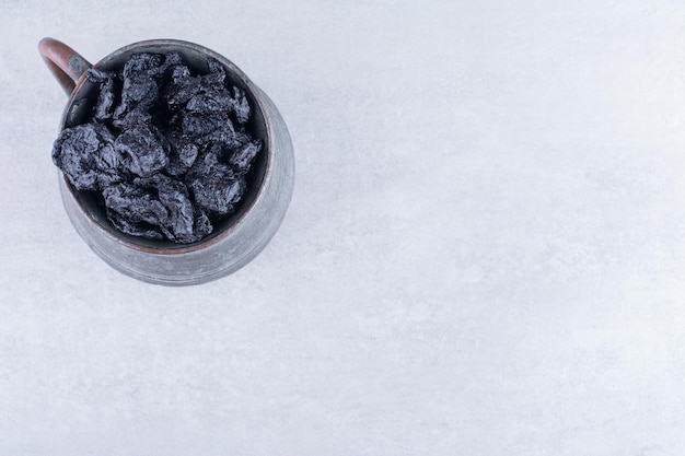 Black dried sultanas isolated on concrete background. High quality photo