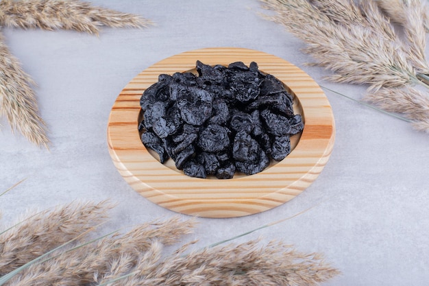 Black dried sultanas isolated on concrete background. High quality photo