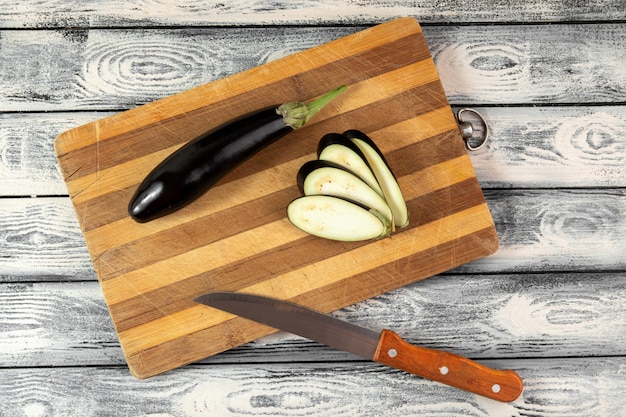 Black eggplant mellow bright sliced on wooden desk and grey background