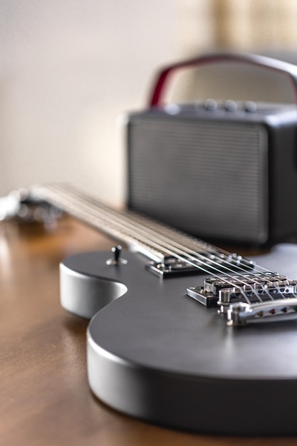 木製のテーブル上の黒いエレクトリックギターとスピーカー