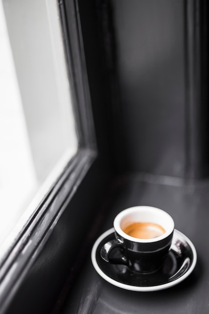 黒の空のコーヒーカップ、窓の敷居にコーヒーの汚れ