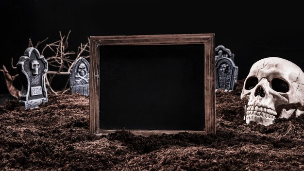 Черный пустой знак, стоящий на кладбище с черепом