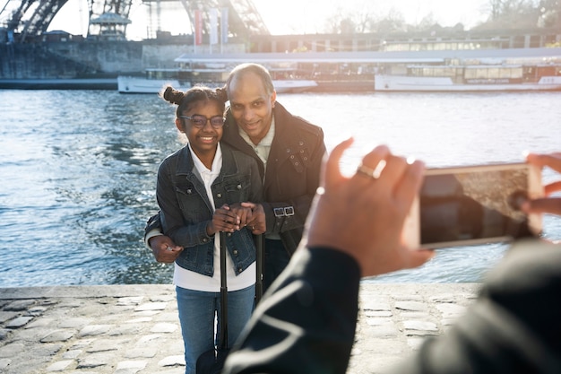 Foto gratuita famiglia nera che scatta una foto durante il viaggio a parigi