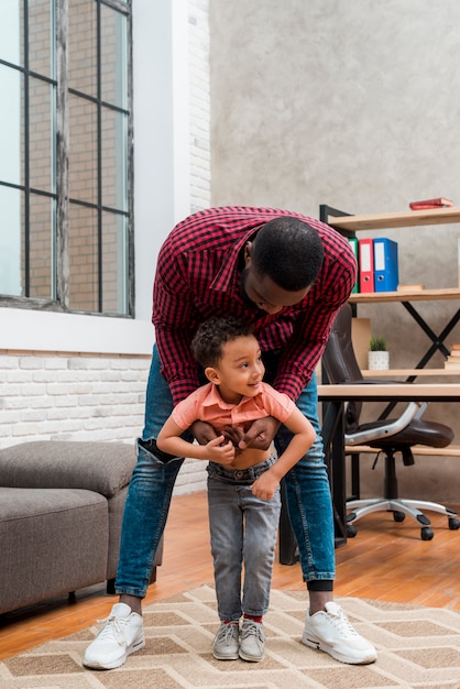 Black father hugging little son 