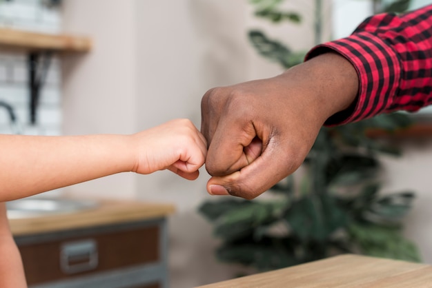 Free photo black father and son bumping fists