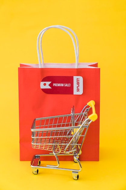 Black friday composition with cart in front of red bag