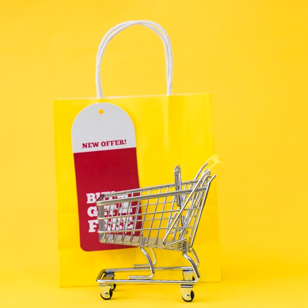 Black friday composition with cart in front of yellow bag