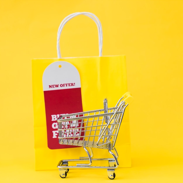 Black friday composition with cart in front of yellow bag