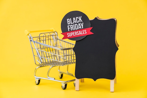 Black friday composition with cart and label on board