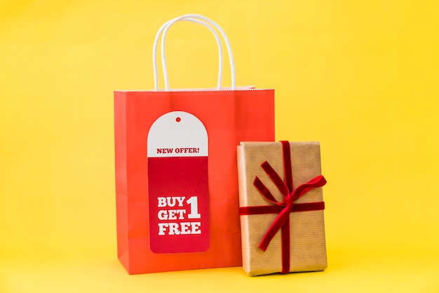 Black friday composition with gift box leaning against bag