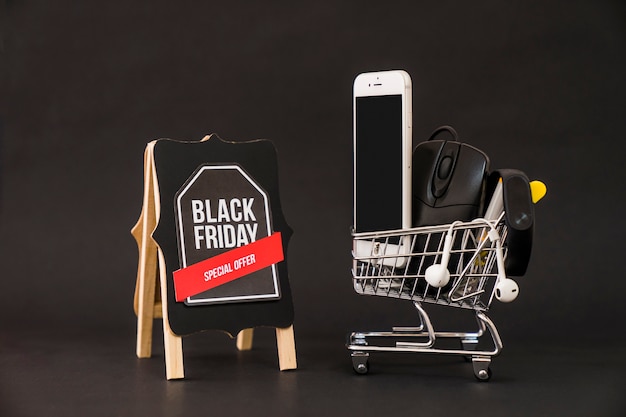 Концепция Black friday со смартфоном в корзине рядом с доской