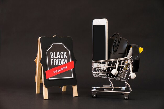 Black friday concept with smartphone in cart next to board