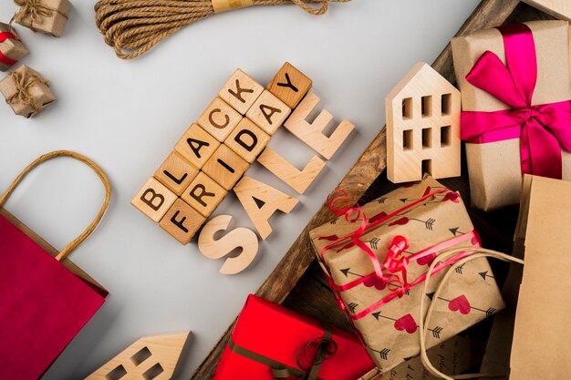 Black friday cubes and presents on plain and wooden background