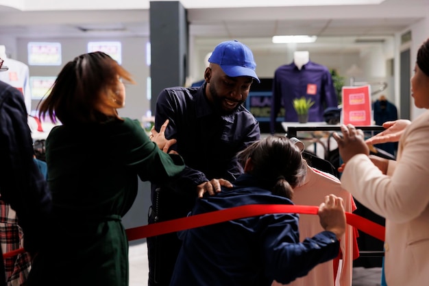 Free photo black friday and cyber monday madness. frenzied people shoppers going crazy by sales, bargain-hunters breaking into clothing store, security worker holding back crowd at shopping mall entrance