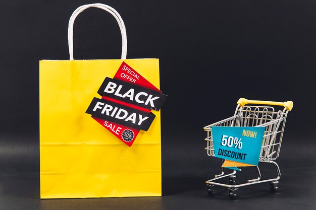 Black friday discount composition with bag and cart