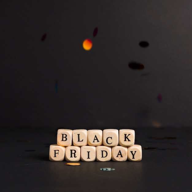 Black Friday inscription on cubes with bright confetti