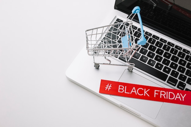 Free photo black friday laptop and shopping cart with copy space