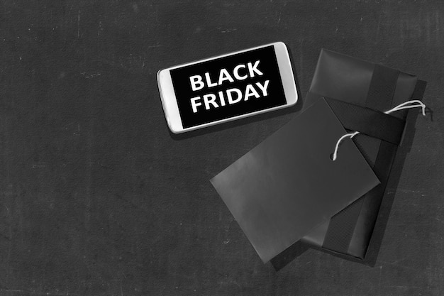 Black Friday message on the mobile phone screen with label tag on black background. Black Friday concept