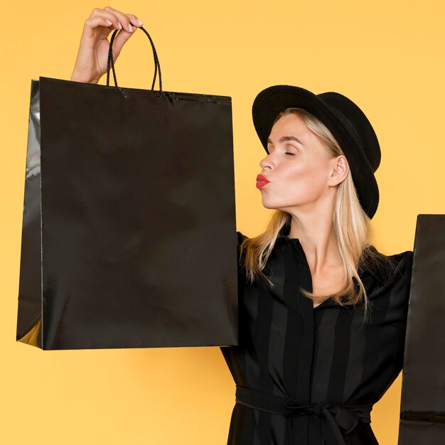 Black friday sale concept woman kissing shopping bag gesture