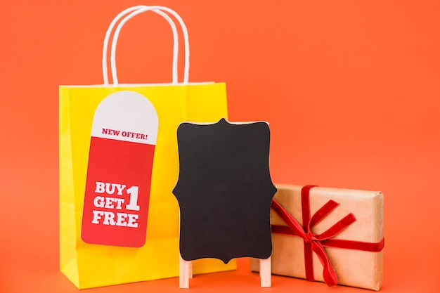 Концепция продажи черного пятна с сумкой и подарочной коробкой за доской