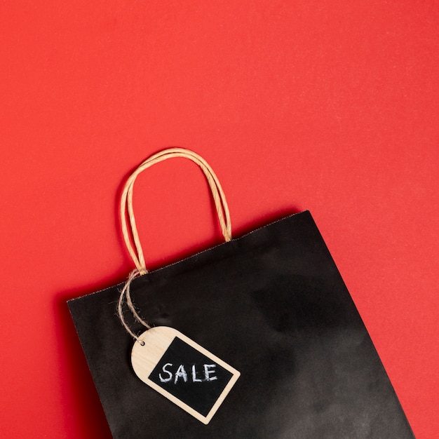 Free photo black friday sales paper bag on red background