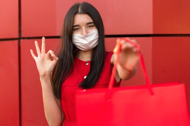 Foto gratuita donna di vendita venerdì nero che indossa segno ok maschera